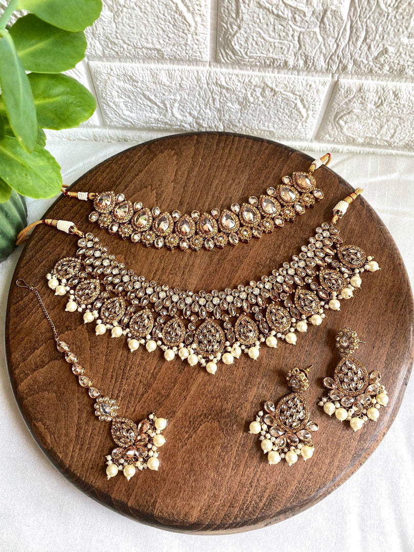 This vibrant Indian Bridal Jewelry set includes a necklace, earrings and tikka.  Elevate your traditional Desi Wedding look with custom color and design options available through WhatsApp order at +1313-727-1045.  Place your order now and make a bollywood style statement with this stunning set!