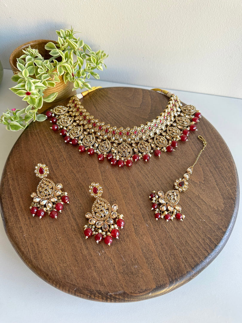 This vibrant Indian Bridal Jewelry set includes a necklace, earrings and tikka.  Elevate your traditional Desi Wedding look with custom color and design options available through WhatsApp order at +1313-727-1045.  Place your order now and make a bollywood style statement with this stunning set!